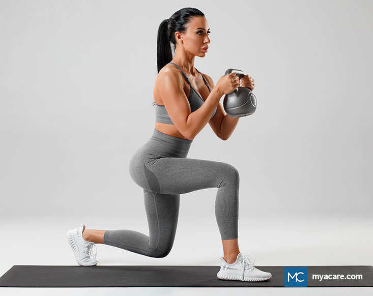 Person in active wear doing a forward lunge with a kettlebell